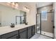 Modern bathroom featuring double sinks, vanity with storage, and walk-in shower at 9645 Browns Peak Cir, Littleton, CO 80125