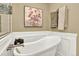 Bright bathroom featuring a soaking tub with elegant fixtures and a decorative painting at 10112 Bluffmont Ln, Lone Tree, CO 80124