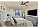Bedroom with ceiling fan, carpet, neutral paint, large window, and dresser with TV at 10112 Bluffmont Ln, Lone Tree, CO 80124