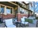 Inviting front porch with comfortable seating and brick accents at 10112 Bluffmont Ln, Lone Tree, CO 80124