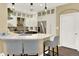 Kitchen boasts stainless steel appliances, pendant lights, white cabinets, and a breakfast bar at 10112 Bluffmont Ln, Lone Tree, CO 80124