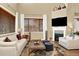 Bright living room with fireplace, TV, plush seating, and large windows with window coverings at 10112 Bluffmont Ln, Lone Tree, CO 80124