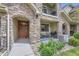 Charming front porch with stone pillars, seating area, and a welcoming front door at 15362 W 66Th Ave # D, Arvada, CO 80007