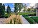 Well-maintained landscaped path through the community with vibrant greenery, ornamental grasses, and mature trees at 15362 W 66Th Ave # D, Arvada, CO 80007