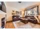 Spacious living room with hardwood floors, comfortable leather seating, and a cozy, warm fireplace at 15362 W 66Th Ave # D, Arvada, CO 80007