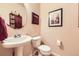 The powder room has a pedestal sink, round mirror, and decorative art at 15362 W 66Th Ave # D, Arvada, CO 80007