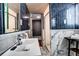 Bathroom featuring black and white tiles, shower, and a large mirror at 306 S Newport Way, Denver, CO 80224