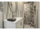 Modern bathroom featuring a white vanity, unique shower tile design, and sleek fixtures at 306 S Newport Way, Denver, CO 80224