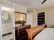 Bedroom featuring an ensuite bathroom, built-in storage, neutral paint, and a large window for natural light at 306 S Newport Way, Denver, CO 80224