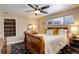 Bedroom features a sleigh bed, ceiling fan, neutral paint, and a side window for natural light at 306 S Newport Way, Denver, CO 80224