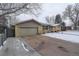 Single story home with an attached garage and snow covered yard at 306 S Newport Way, Denver, CO 80224