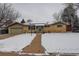 Classic home featuring a brick facade and a snow-covered yard at 306 S Newport Way, Denver, CO 80224