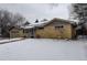 Ranch-style home featuring a brick facade and snow covered yard at 306 S Newport Way, Denver, CO 80224