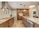 An open kitchen features a breakfast bar, granite countertops, stainless appliances, and wood-look tile flooring at 306 S Newport Way, Denver, CO 80224