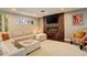 A cozy living area boasts a linear fireplace, mounted TV, neutral paint, and a comfortable sectional sofa at 306 S Newport Way, Denver, CO 80224