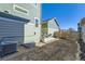 View of the backyard, showcasing the home's exterior, AC, and landscaping at 2572 Iola St, Aurora, CO 80010