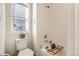 Clean white tiled shower and tub with a window providing natural light in this well-appointed bathroom at 2572 Iola St, Aurora, CO 80010