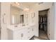 Bright bathroom featuring double vanity sinks, and an open closet area for optimal storage at 2572 Iola St, Aurora, CO 80010