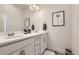 Bright bathroom featuring double sinks, white cabinets, quartz countertop, and minimalist wall art at 2572 Iola St, Aurora, CO 80010