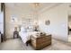 Bright bedroom with tray ceiling, decorative chandelier, and a wooden trunk at the end of the bed at 2572 Iola St, Aurora, CO 80010