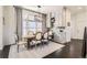 Elegant dining room with a wooden table, six chairs, and a large window with sheer curtains at 2572 Iola St, Aurora, CO 80010