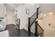 Bright foyer featuring dark wood floors, a staircase with black railings, and ample natural light at 2572 Iola St, Aurora, CO 80010