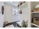 Well-organized mudroom with white built-in shelving, hooks, seating and dark wood floors at 2572 Iola St, Aurora, CO 80010