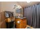 Cozy bathroom with brown walls, wood cabinet vanity, and decorative floral accents on the mirror at 11485 Pecos St, Denver, CO 80234