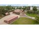 Stunning turreted home with brick and wood, expansive yard, and barn-style outbuildings on a sunny day at 11485 Pecos St, Denver, CO 80234