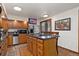 Well-lit kitchen with a center island, stainless steel appliances, and wooden cabinetry at 11485 Pecos St, Denver, CO 80234
