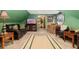 The green walled bonus room features a leather sofa and chair with wood accents at 11485 Pecos St, Denver, CO 80234