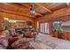 Inviting living room with wood-paneled walls, beamed ceiling, and comfortable leather seating arrangement at 11485 Pecos St, Denver, CO 80234