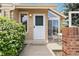Inviting front entrance featuring a white door, surrounded by lovely greenery and a well-kept yard at 2136 S Scranton Way, Aurora, CO 80014
