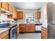 Functional kitchen with stainless steel appliances, ample counter space, and wood cabinets at 2136 S Scranton Way, Aurora, CO 80014