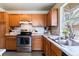 Well-lit kitchen featuring wood cabinets, stainless appliances, and a backyard view at 2136 S Scranton Way, Aurora, CO 80014
