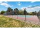 Outdoor tennis courts with red and green surfaces, surrounded by a high fence and lush greenery at 2136 S Scranton Way, Aurora, CO 80014