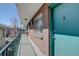 A brick balcony is adjacent to a blue exterior door and has a metal railing overlooking neighborhood at 1140 N Downing St # 303, Denver, CO 80218