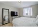 Bedroom featuring a large bed, full-length mirror, a large screen tv, and a window with decorative curtains at 1140 N Downing St # 303, Denver, CO 80218