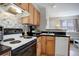 Bright kitchen with stainless steel appliances, light wood cabinets, a white sink, and a view into the living area at 1140 N Downing St # 303, Denver, CO 80218