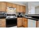 Compact kitchen featuring wood cabinets, black appliances, tile backsplash, and black counter tops at 1140 N Downing St # 303, Denver, CO 80218