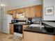 The kitchen has wooden cabinets, black countertops, a white refrigerator, and updated backsplash at 1140 N Downing St # 303, Denver, CO 80218