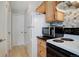 Functional kitchen featuring stainless steel microwave, white appliances, light wood cabinets, and stylish backsplash at 1140 N Downing St # 303, Denver, CO 80218