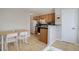 Bright kitchen with wooden cabinets, a white refrigerator, and an adjacent dining area with table and chairs at 1140 N Downing St # 303, Denver, CO 80218