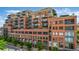 Full building exterior showing brick facade, street trees, and multiple balconies at 1499 Blake St # 4F, Denver, CO 80202