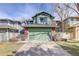 Inviting green exterior showcasing a two-story home with an attached two-car garage and brick accents at 8254 S Gaylord Cir, Centennial, CO 80122