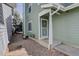 View of the side entry showcasing a storm door, exterior lights, and tidy stone landscaping at 8254 S Gaylord Cir, Centennial, CO 80122