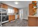 Functional kitchen with wood cabinets, modern appliances, and a view of a well-stocked pantry at 3190 W Hawthorne Pl, Denver, CO 80221