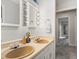 Bathroom featuring double sinks, Hollywood lighting, and neutral wall paint and flooring at 6700 W 11Th Ave # 103, Lakewood, CO 80214