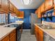 Kitchen featuring oak cabinetry, stainless steel appliances, and a blue accent wall at 6700 W 11Th Ave # 103, Lakewood, CO 80214