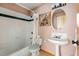 A full bathroom with a tub, shower, toilet, and a single sink with an oval mirror at 11730 Pointe View Dr, Longmont, CO 80503